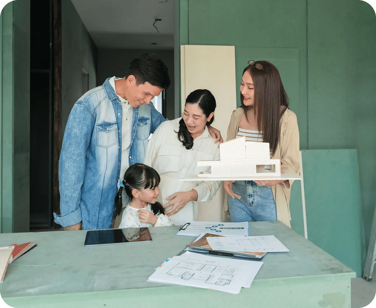 Family with house model and blueprints